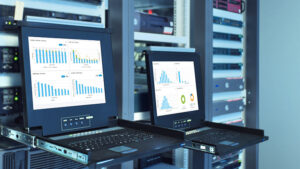 2 computer screens with data in front of servers